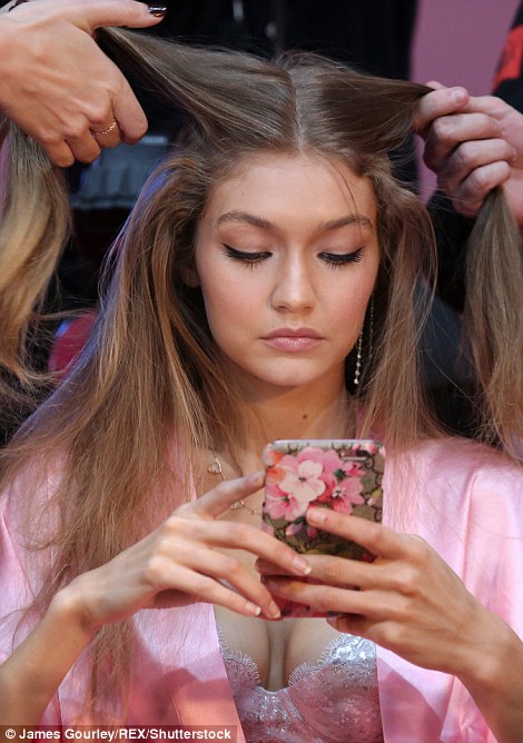 Busty beauty: Gigi was engrossed in her phone as she had her hair yanked to and fro 